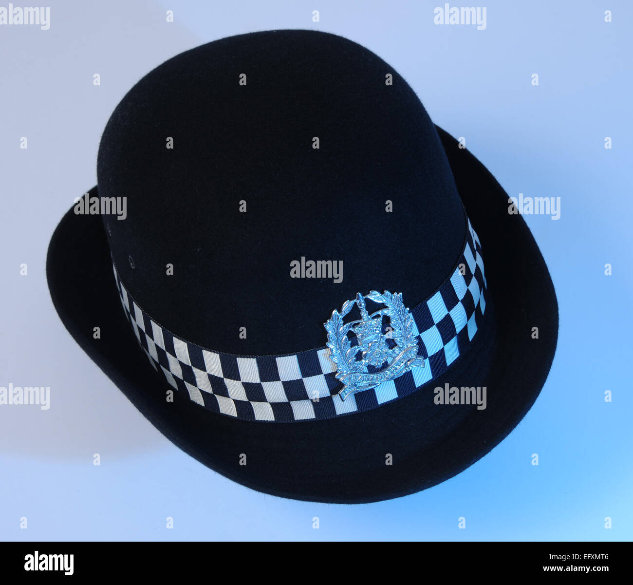 Policeman's uniform helmet with HAMPSHIRE police badge with blue fill light. Stock Photo