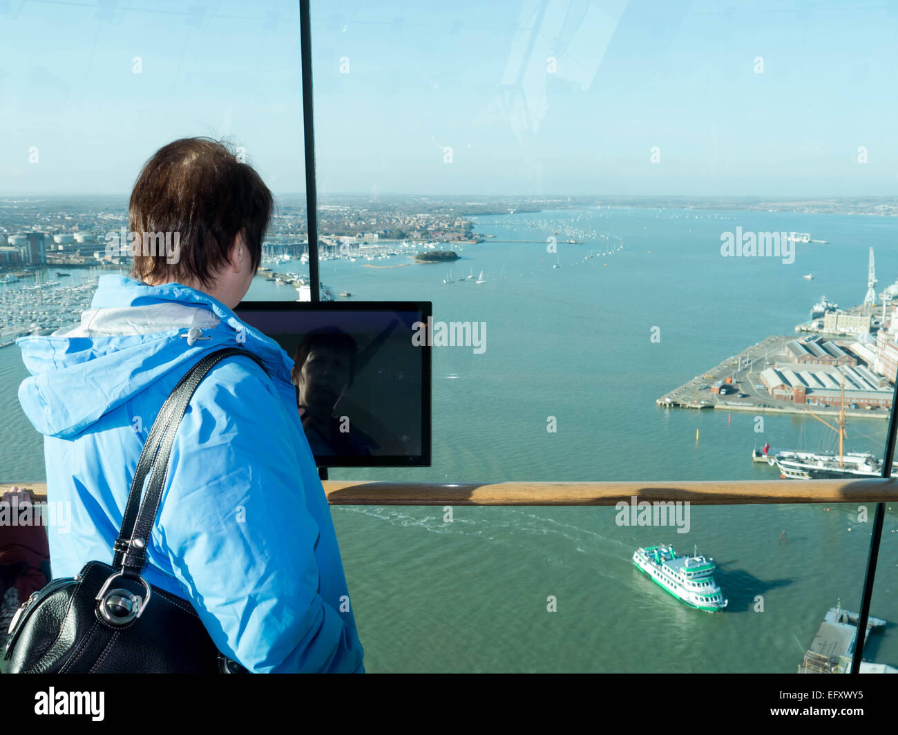 A lady uses a touchpad information point in the Spinnaker tower, Portsmouth, England Stock Photo