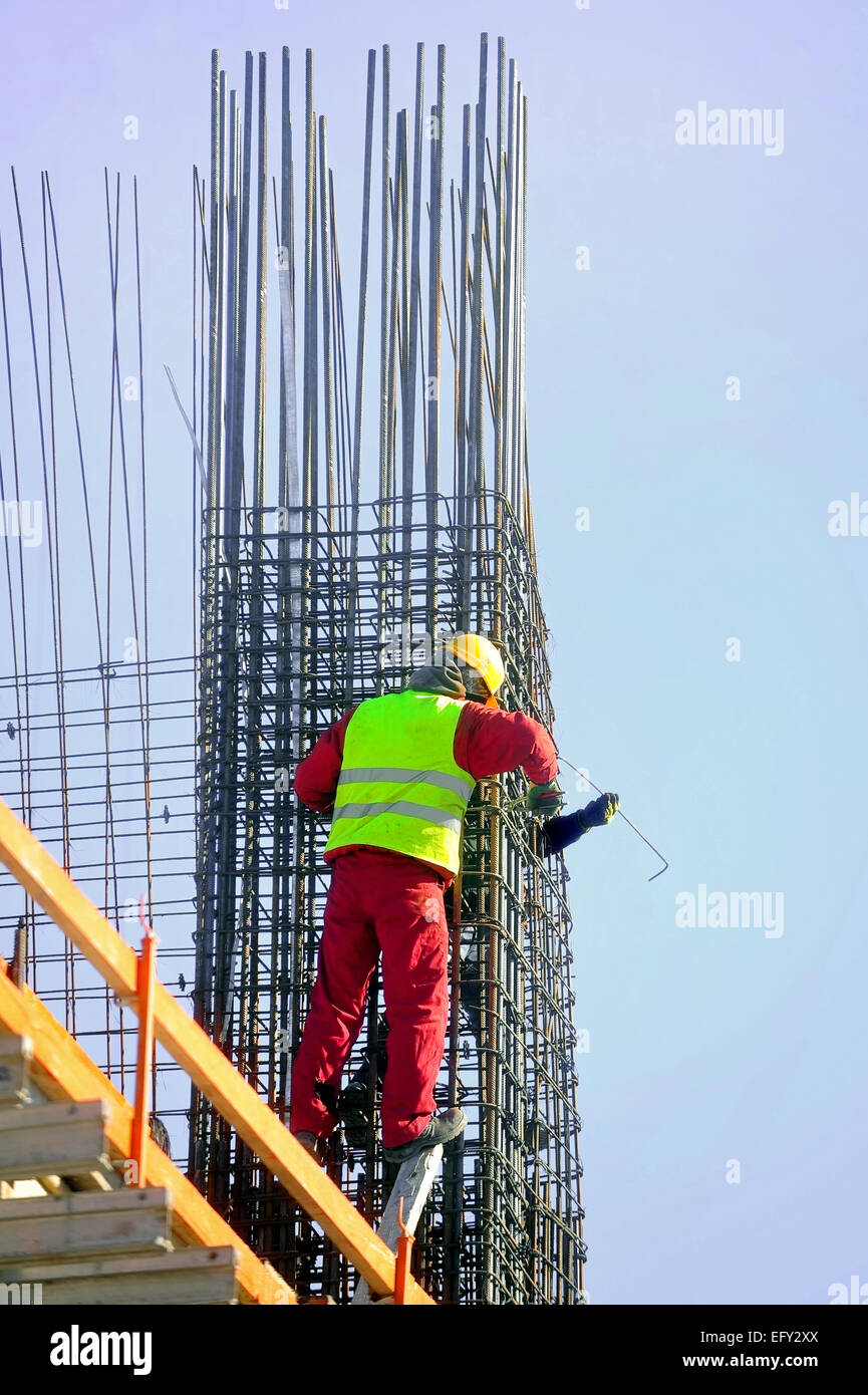 Two construction workers knitting steel rods reinforcement for concrete pouring Stock Photo