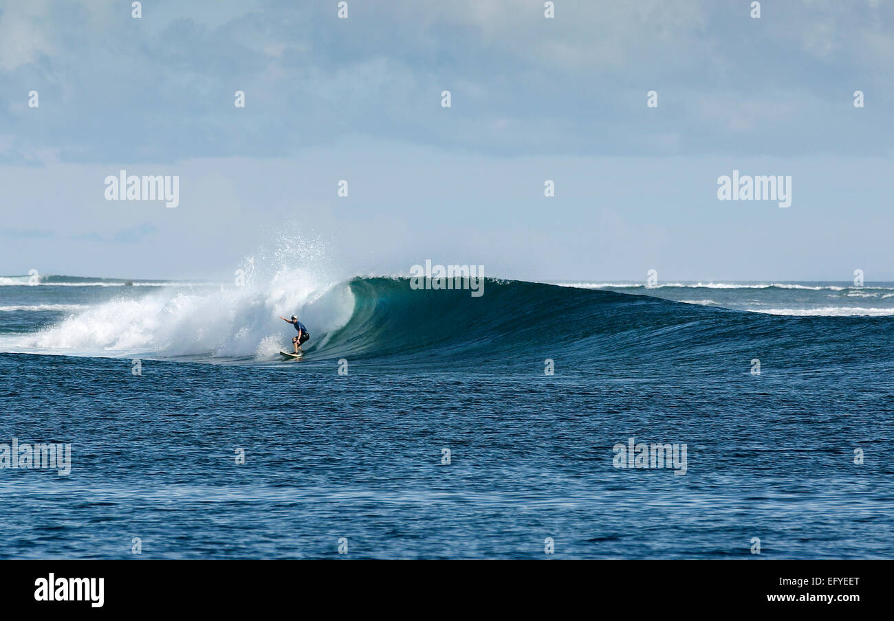 Surfing a large wave in Maluku Islands, Indonesia Stock Photo