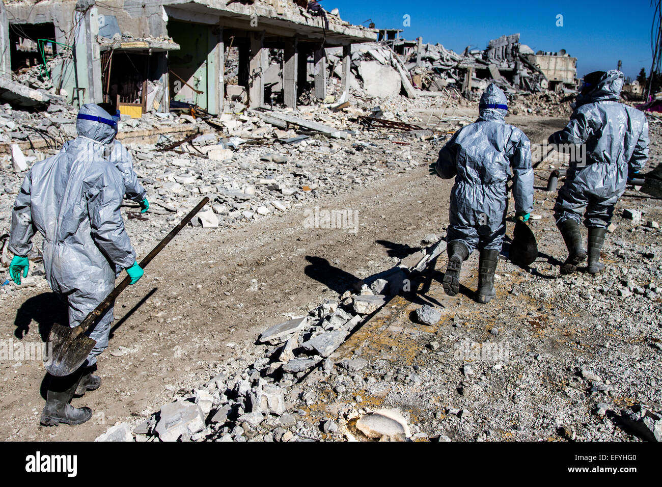 Kobane, Syria. 6th Feb, 2015. A unit of Kurdish YPG fighters wear protective suits as they search the streets for dead bodies and corpses in the ruins of Kobane, Syria, 6 February 2015. The recent fighting between Kurdish fighters and fighters of the so-called Islamic State (IS) has left vast areas of the city of Kobane in ruins. Photo: Sebastian Backhaus/dpa - NO WIRE SERVICE -/dpa/Alamy Live News Stock Photo