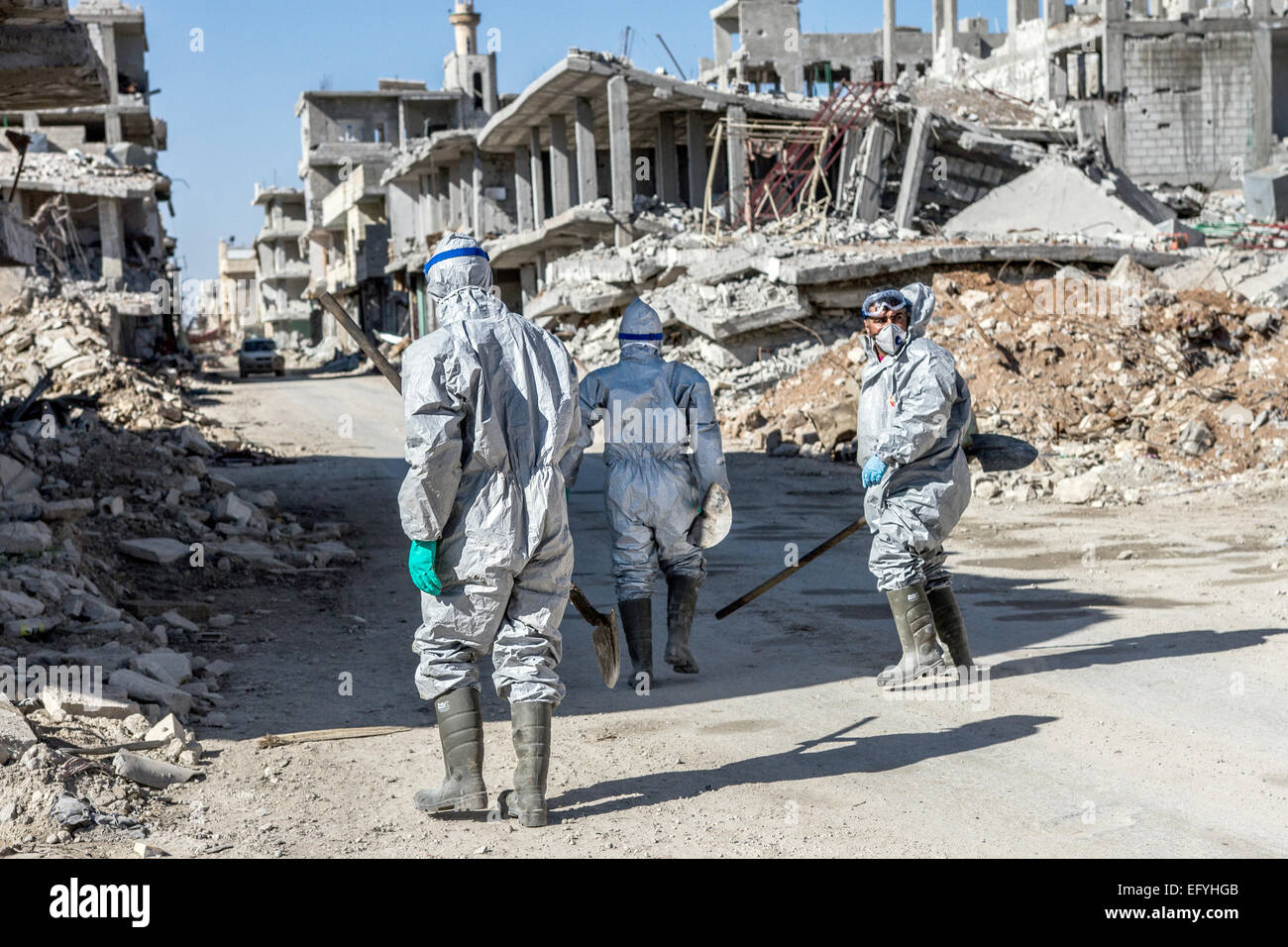 Kobane, Syria. 6th Feb, 2015. A unit of Kurdish YPG fighters wear protective suits as they search the streets for dead bodies and corpses in the ruins of Kobane, Syria, 6 February 2015. The recent fighting between Kurdish fighters and fighters of the so-called Islamic State (IS) has left vast areas of the city of Kobane in ruins. Photo: Sebastian Backhaus/dpa/Alamy Live News Stock Photo