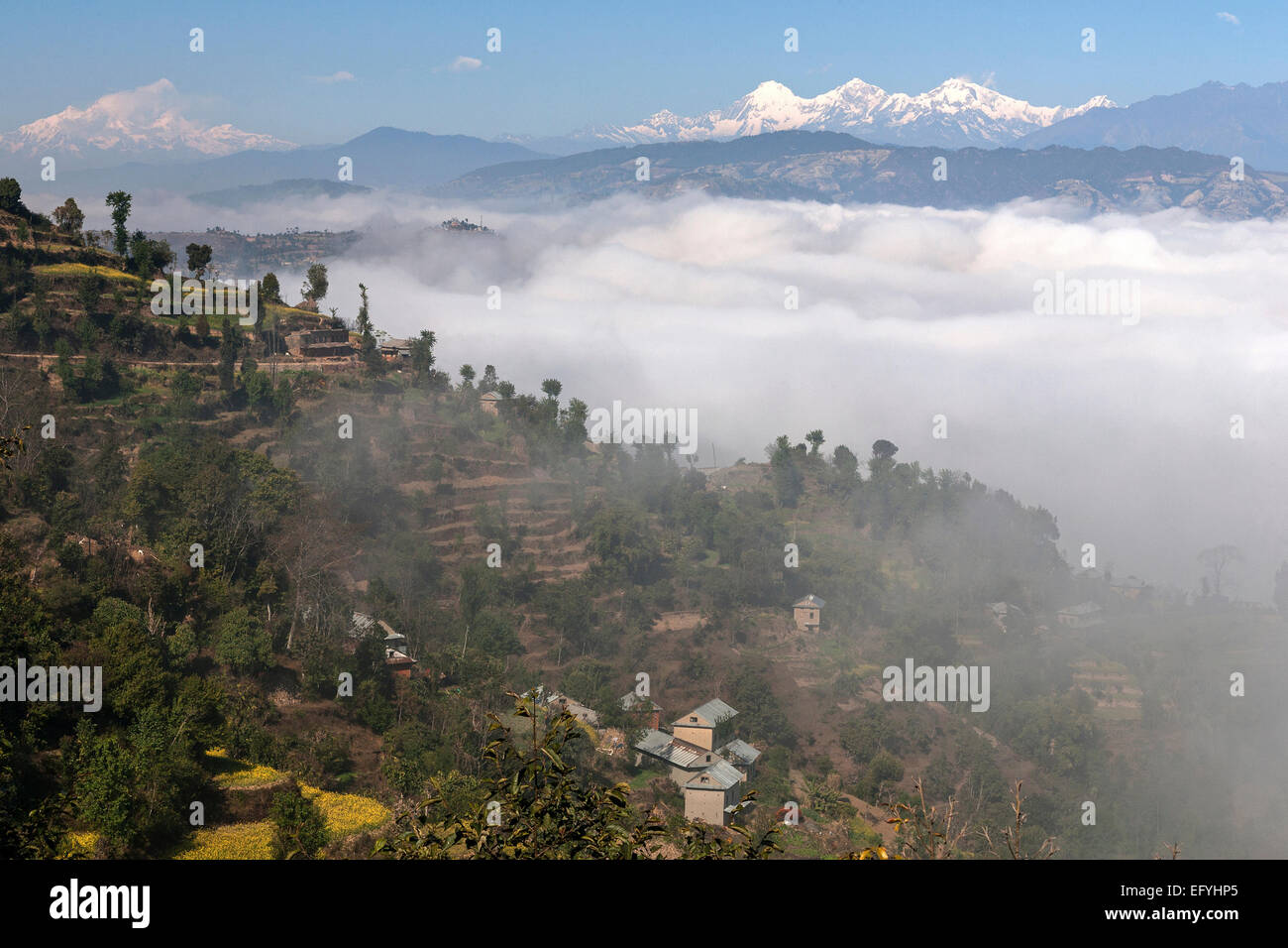 View of the countryside, rural houses, terraced fields and mountains of the Himalayas, fog in the valley, near Dhulikel, Nepal Stock Photo