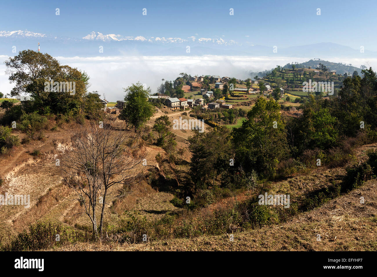 View of the countryside, rural houses, terraced fields and mountains of the Himalayas, fog in the valley, near Dhulikel, Nepal Stock Photo