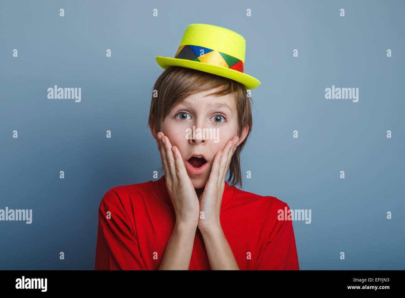 boy teenager European appearance in a red shirt and yellow hat p Stock Photo