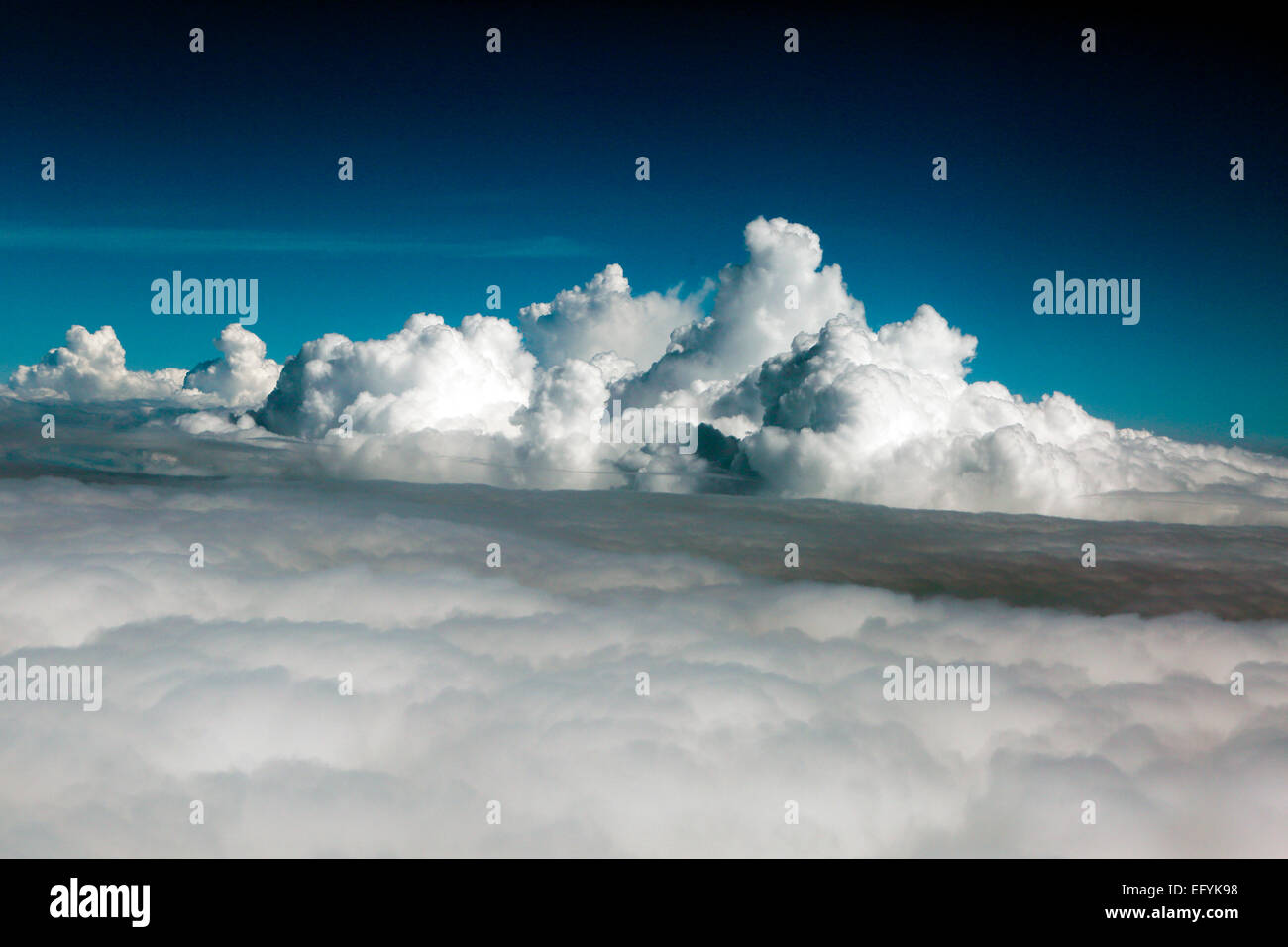 POV plane flying overs clouds with blue sky above Stock Photo