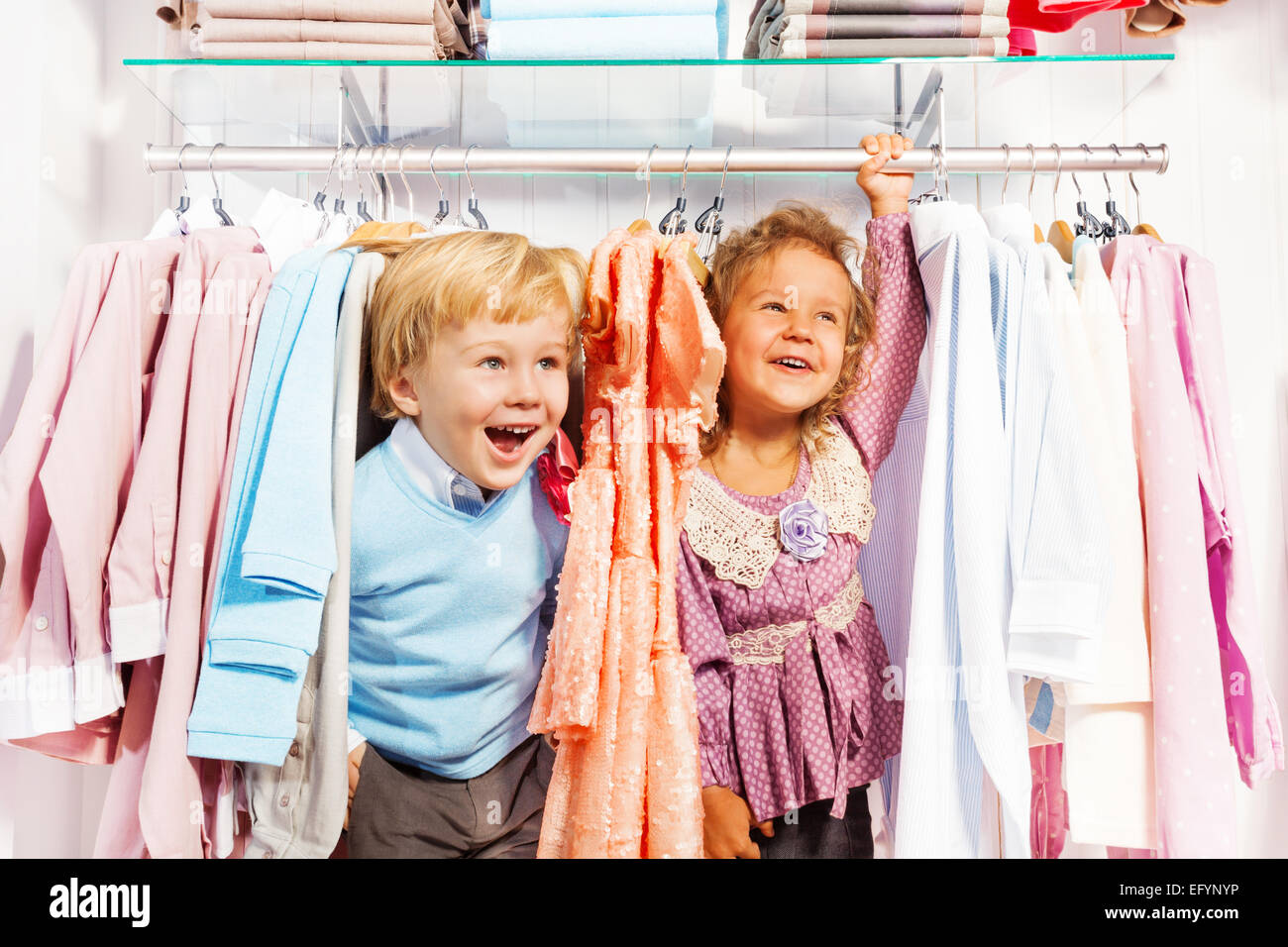 Excited boy and girl play hide-and-seek in store Stock Photo - Alamy