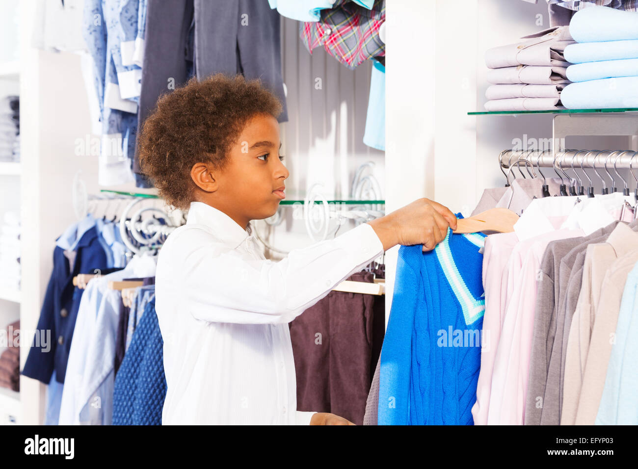 Small African boy in white shirts choosing clothes Stock Photo