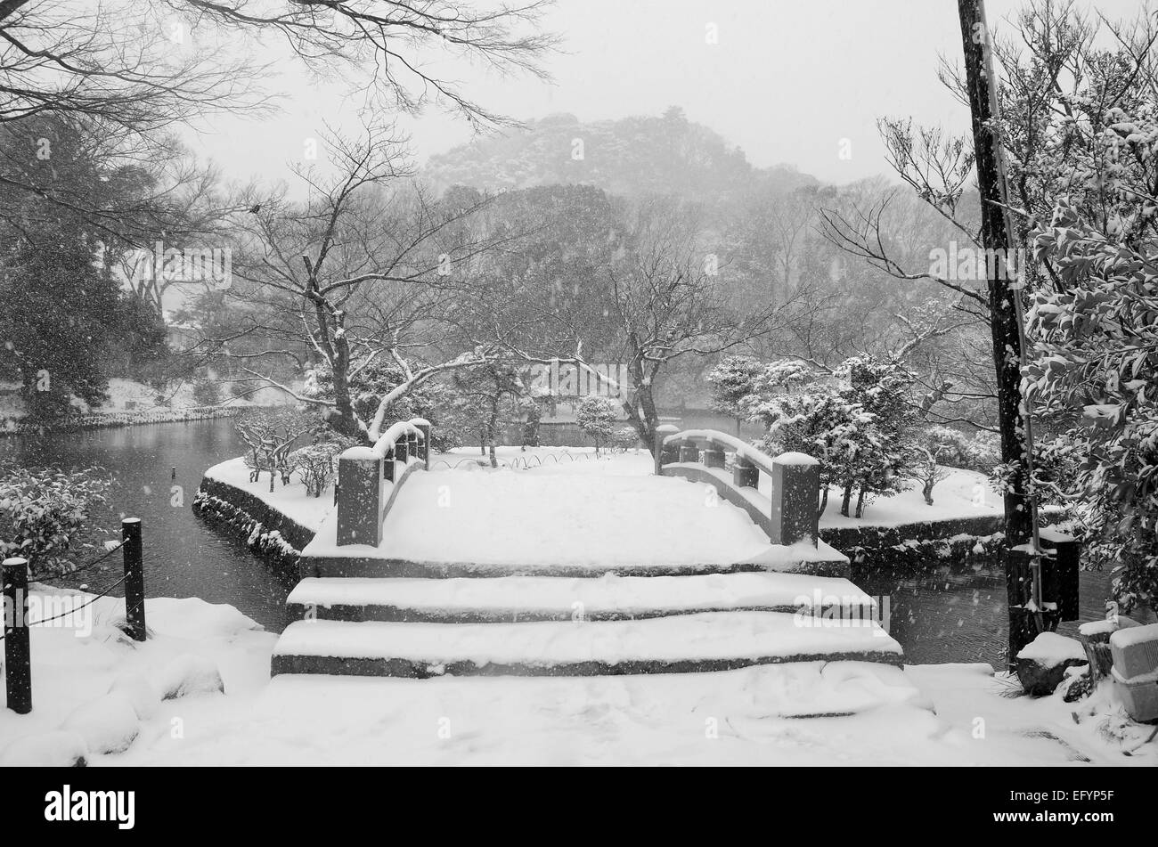 A traditional Japanese bridge covered in snow. Stock Photo
