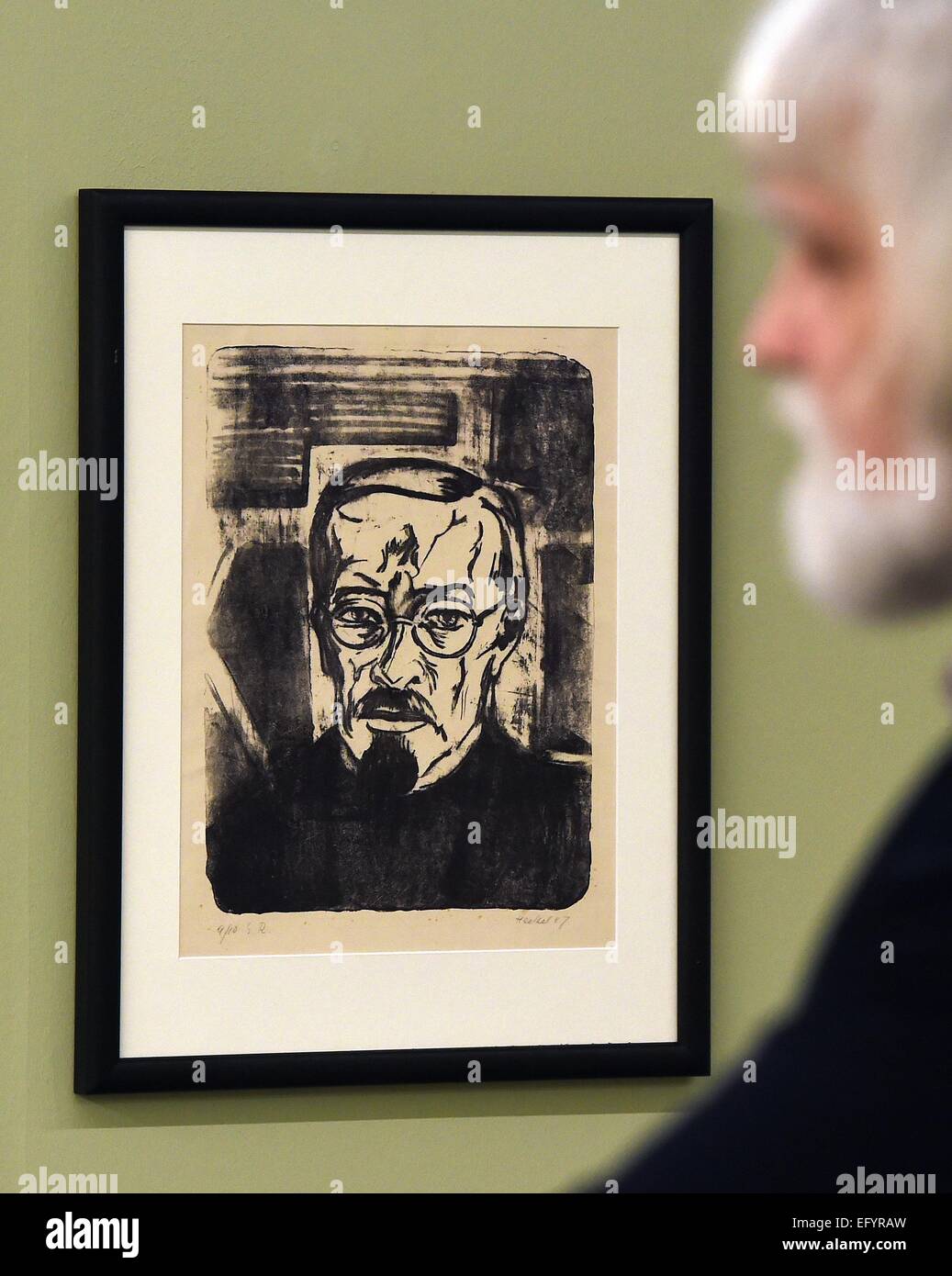 A visitor examines a self-portrait painting by artist Karl Schmidt-Rottluff during a preview tour of the Moritzburg art museum in Halle, Germany, 12 February 2015. The exhibition showcases 70 works of art of various artists of the artist group 'The Bridge'. Photo: Hendrik Schmidt/ZB Stock Photo