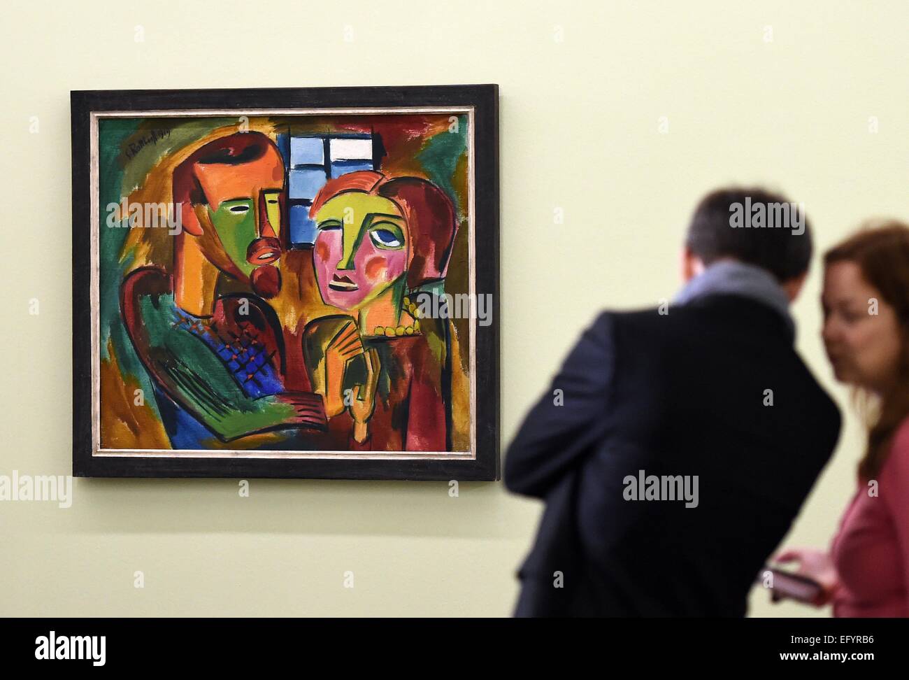 Visitors examine the painting 'Du und ich' (you and me) from 1919 by artist Karl Schmidt-Rottluff during a preview tour of the Moritzburg art museum in Halle, Germany, 12 February 2015. The exhibition showcases 70 works of art of various artists of the artist group 'The Bridge'. Photo: Hendrik Schmidt/ZB Stock Photo