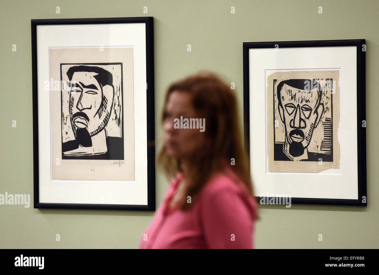 A visitor walks past two self-portrait paintings by artist Karl Schmidt-Rottluff during a preview tour of the Moritzburg art museum in Halle, Germany, 12 February 2015. The exhibition showcases 70 works of art of various artists of the artist group 'The Bridge'. Photo: Hendrik Schmidt/ZB Stock Photo