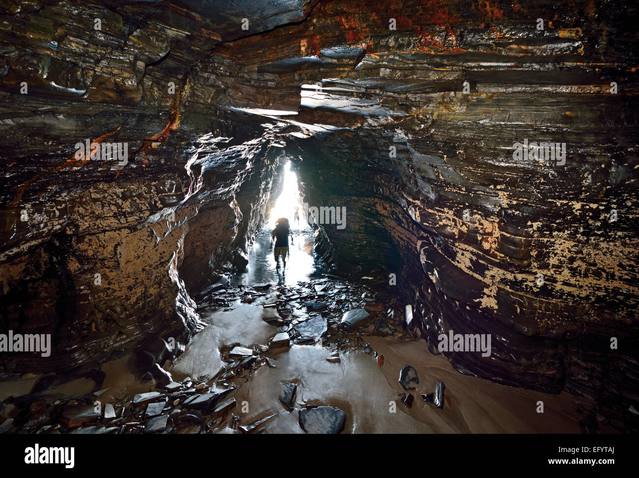 Spain, Galicia: People crossing cave at Cathedral´s beach Stock Photo