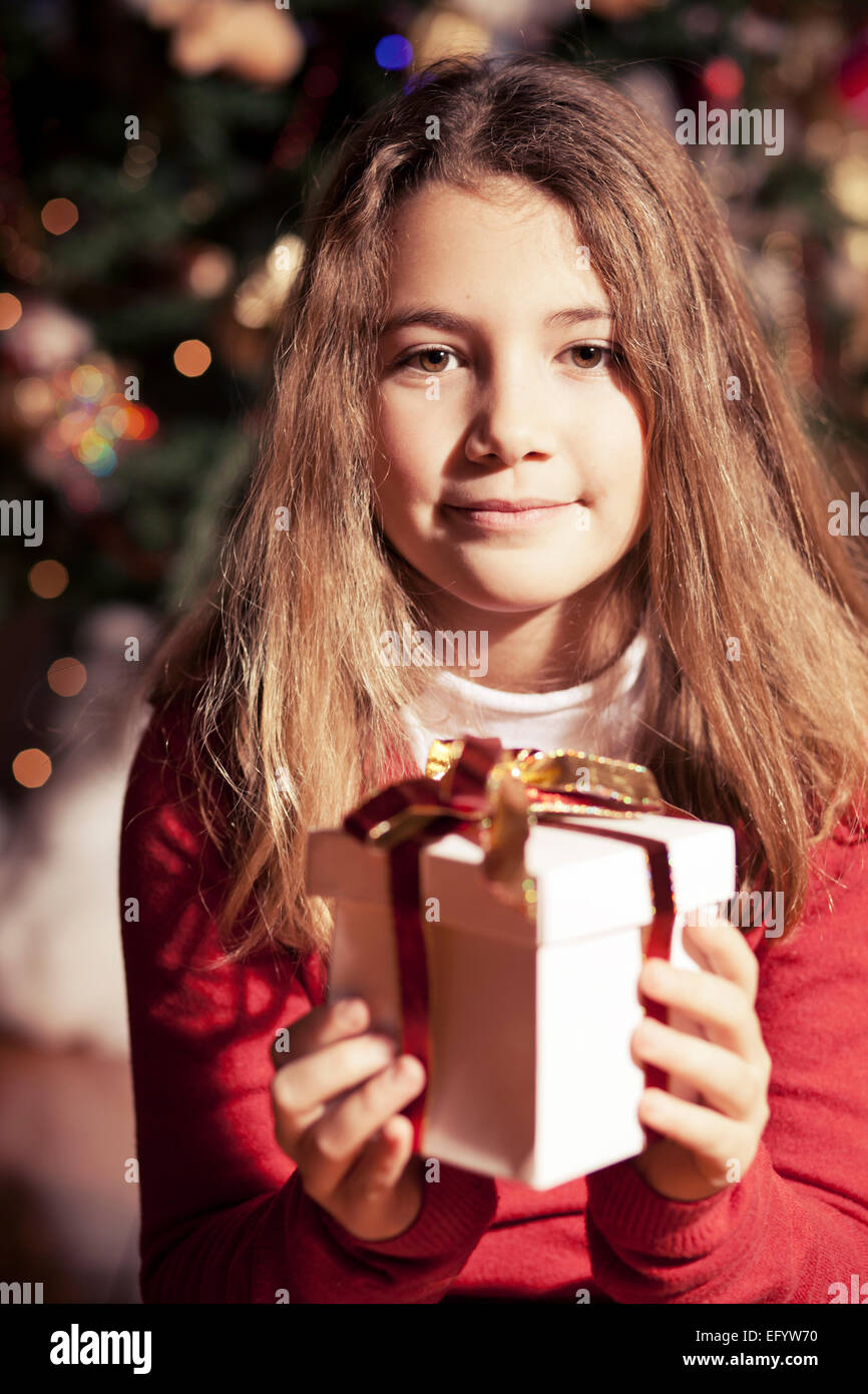 Pretty child offering a present box for Christmas Stock Photo