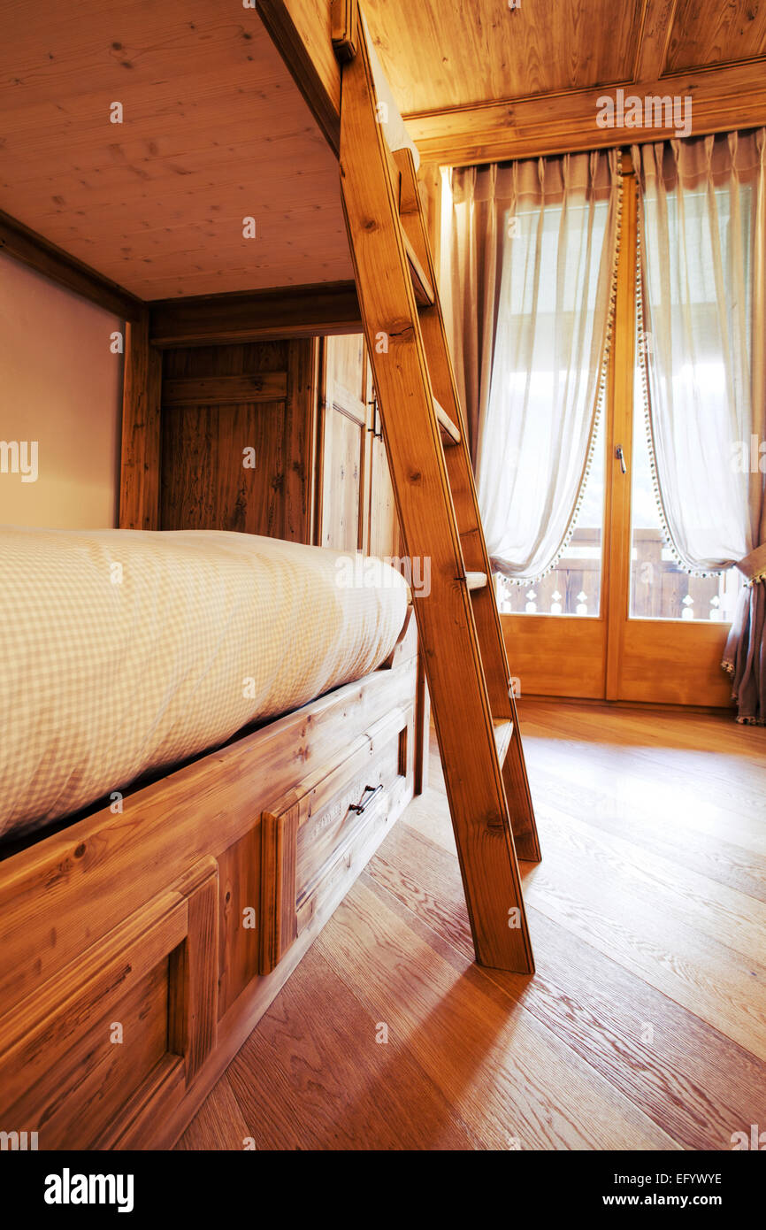 Wooden bunk beds in a children room in a mountain cottage house Stock Photo