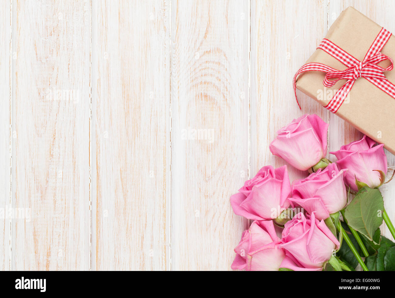 Valentines day background with pink roses and gift box over wooden ...