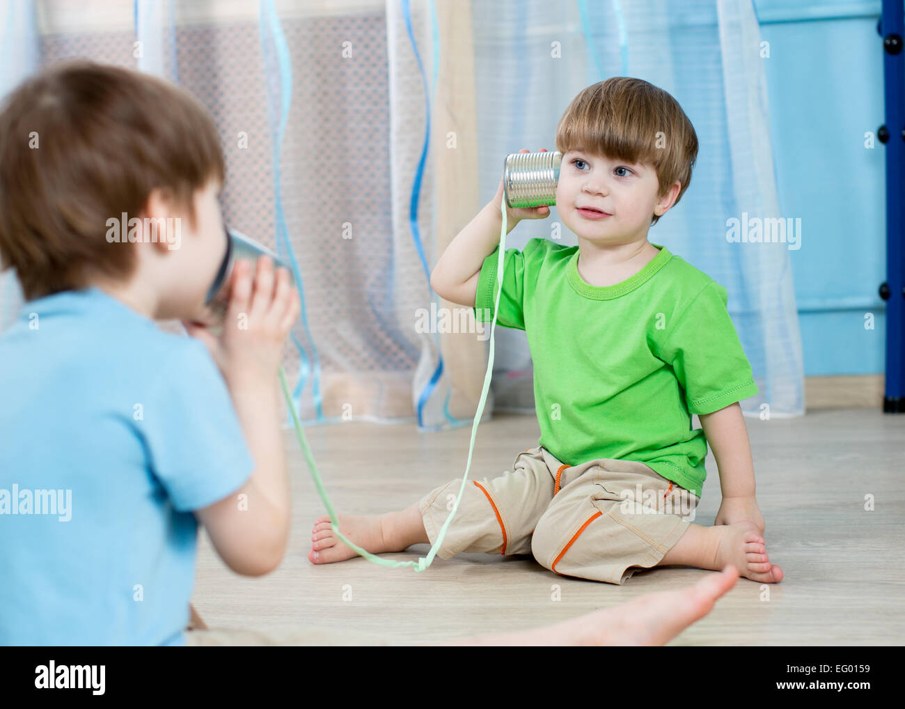 kids brothers talking with tin can telephone Stock Photo