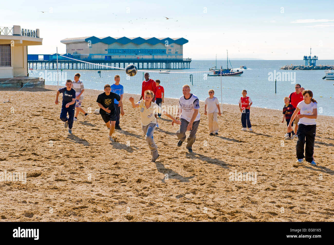 some young people playing a game of football on the beach herne bay kent uk Stock Photo