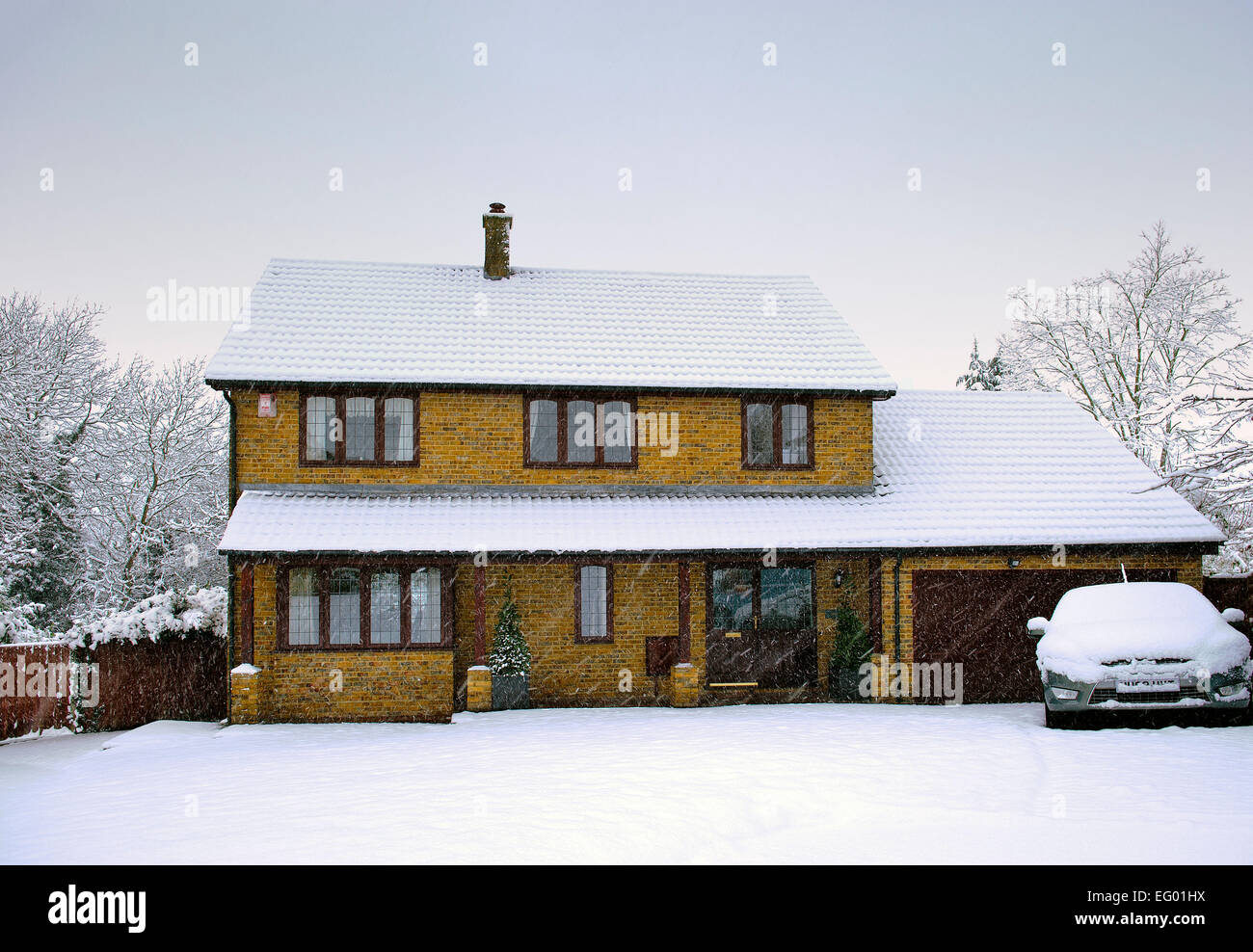 Day time image of large 4 5 bedroom executive style detached house exterior covered in snow Kent UK Stock Photo