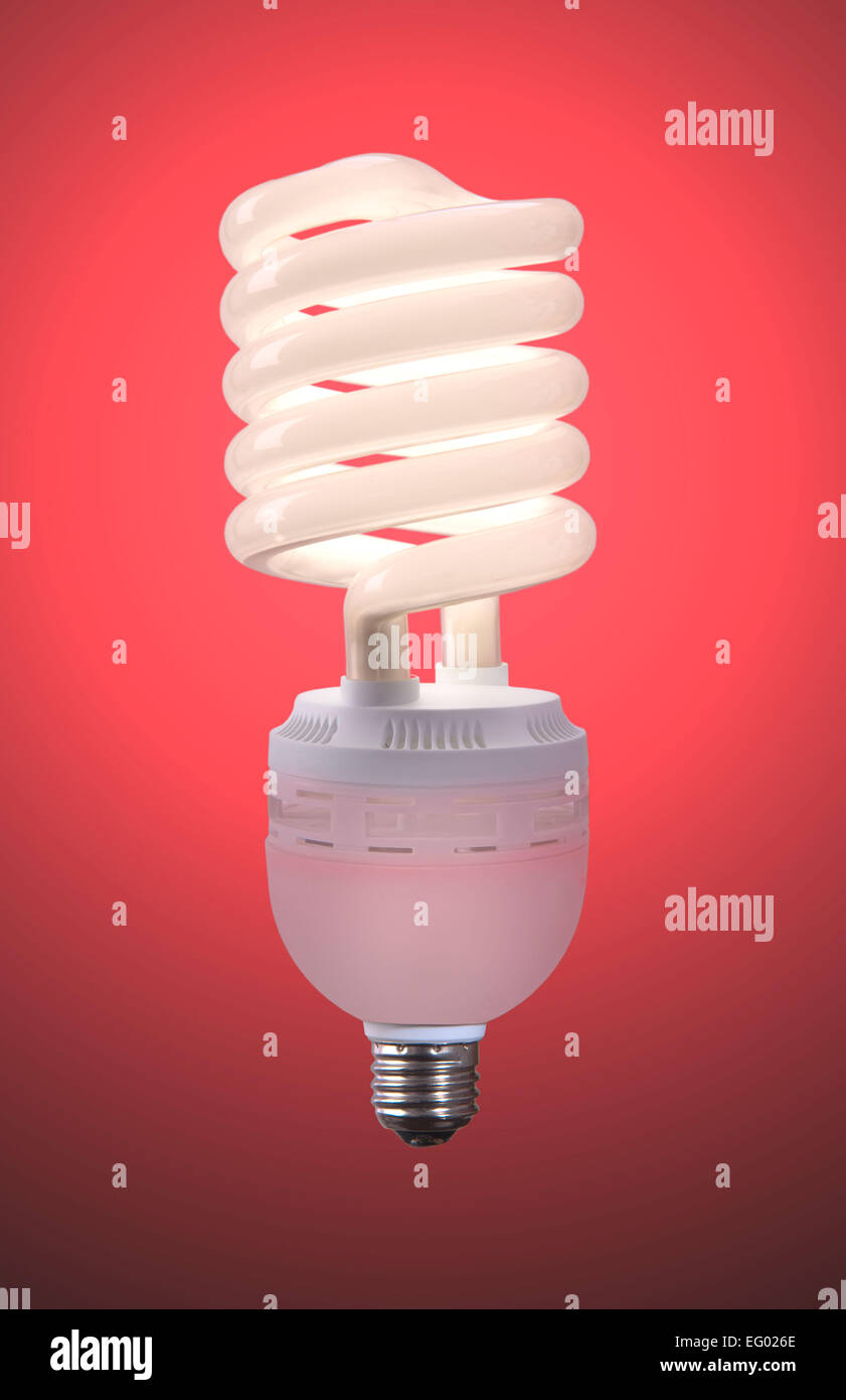 low energy light bulb glowing against a coloured background Stock Photo