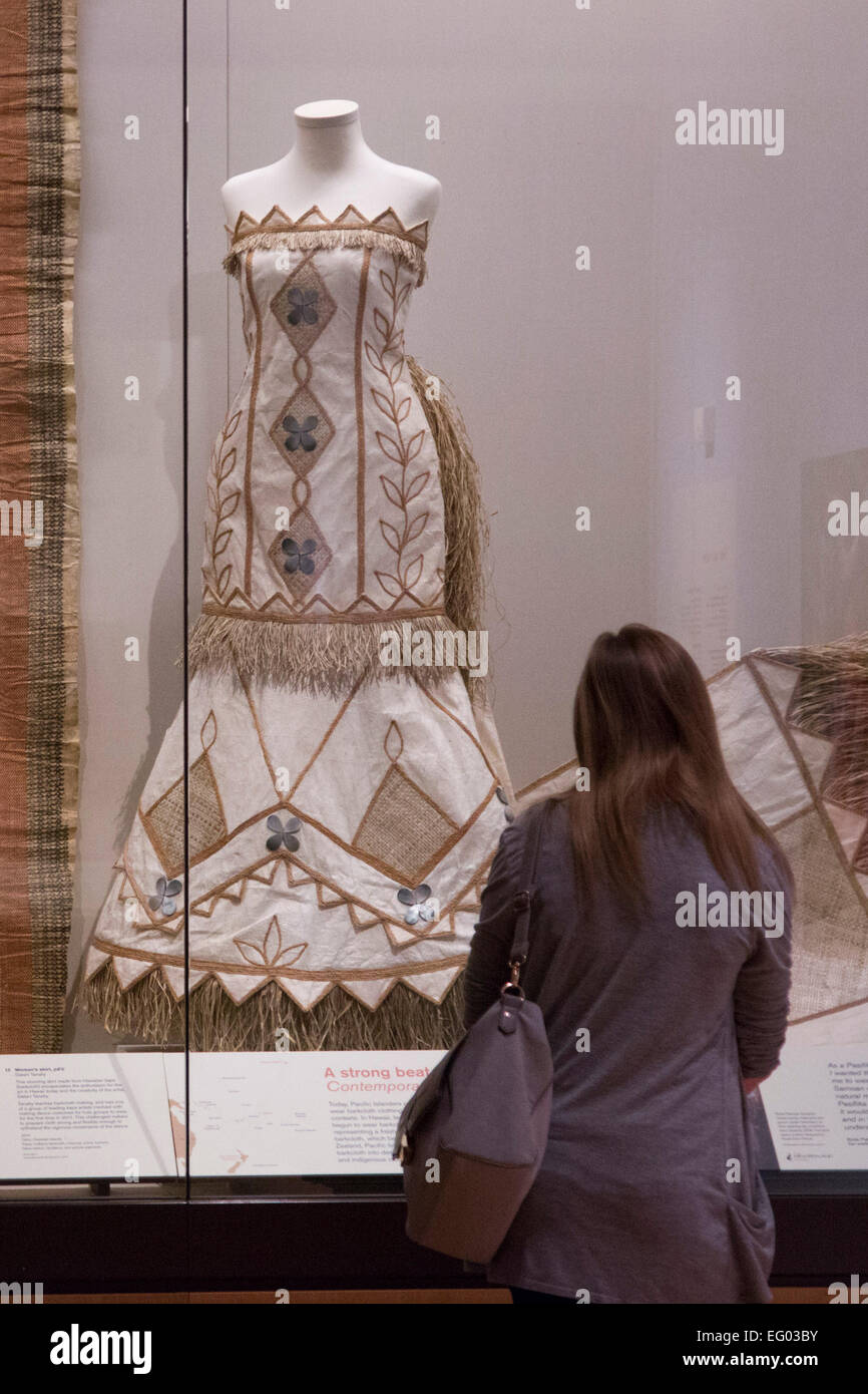 A visitor to the exhibition looks at a wedding dress made of barkcloth ...