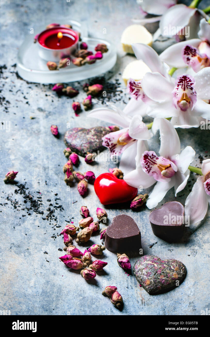Chocolate candies heart shaped with dry tea roses and orchids for Valentine's Day. Stock Photo