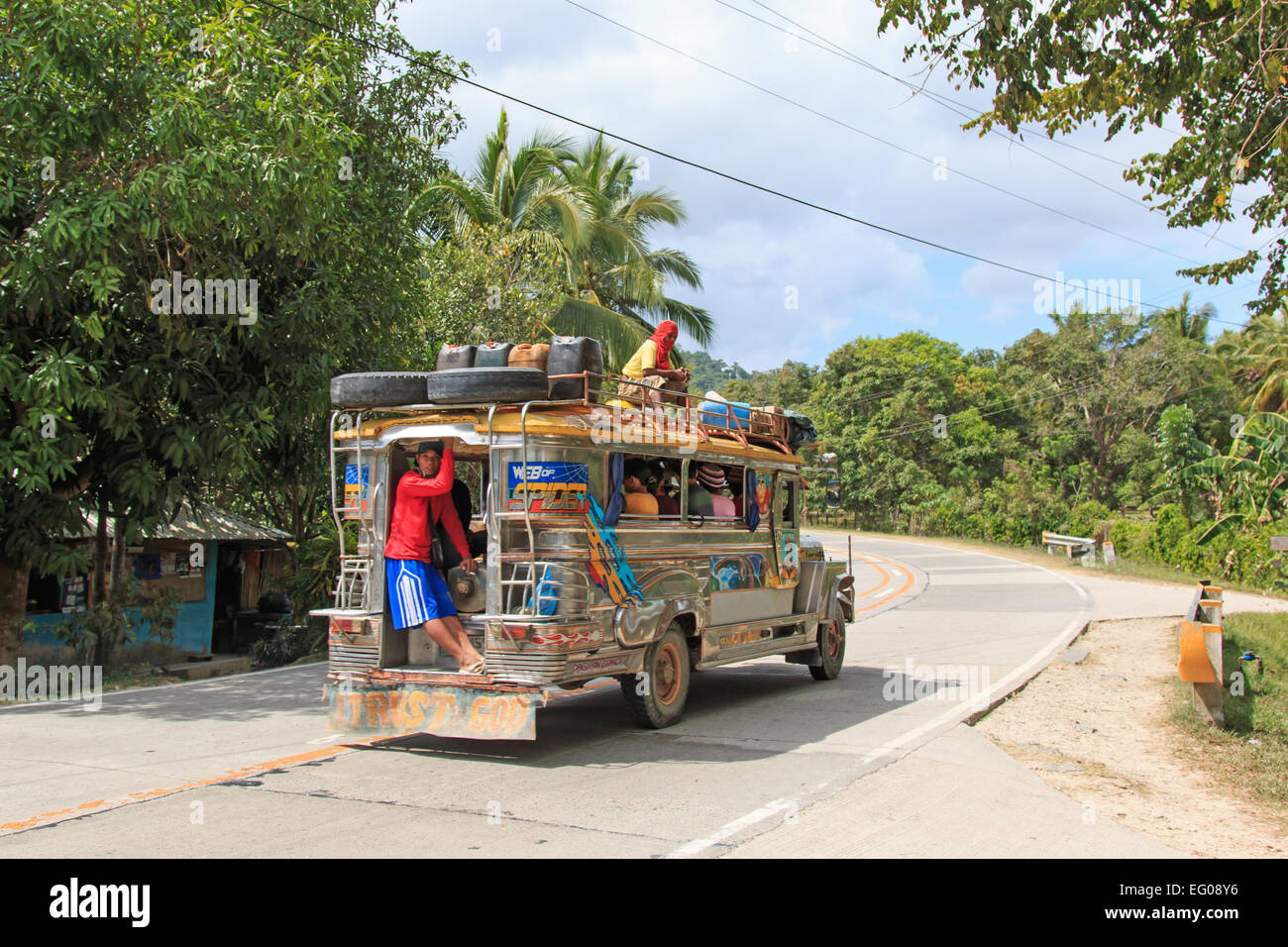 Puerto Princesa, Philippines - January 12, 2015: People in colorful traditional bus jeepney in Palawan, one of the 7107 isalnds Stock Photo