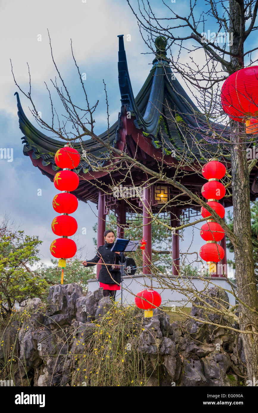 Young woman plays chinese erhu, stringed instrument at  Dr Sun Yat Sen Garden, Chinese New Year celebration, Chinatown, Vancouve Stock Photo