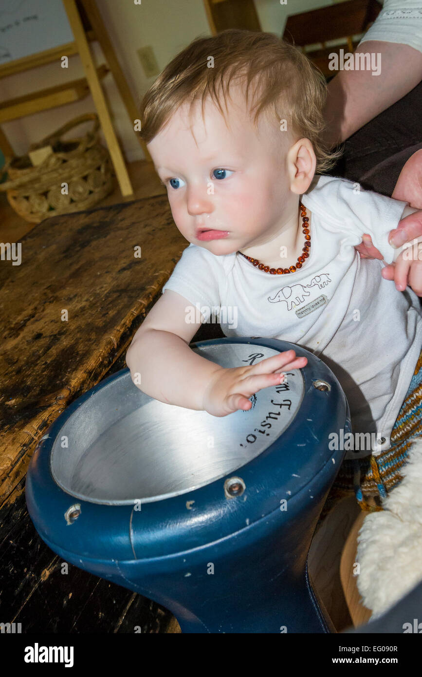 One year old boy playing bongo drum Stock Photo