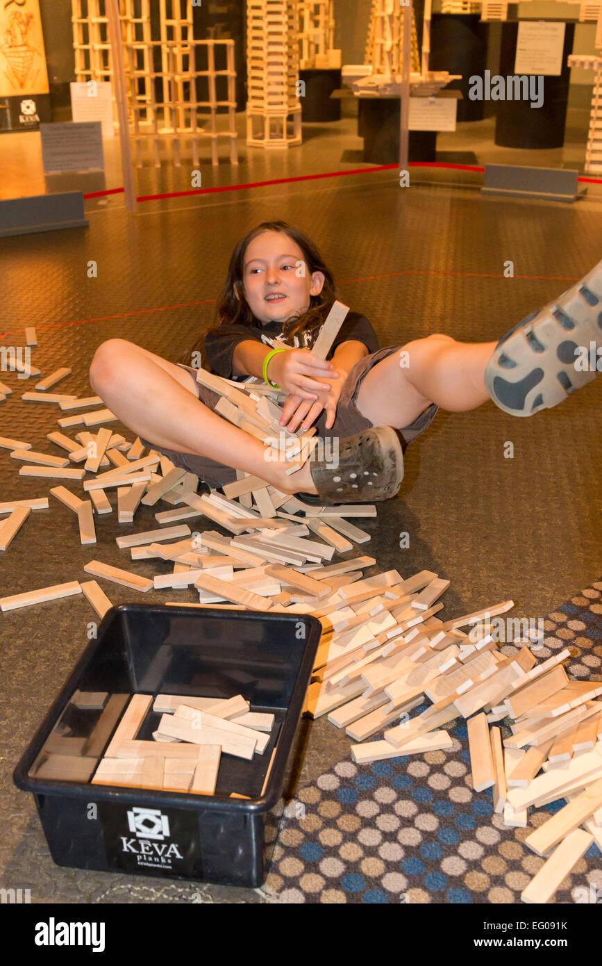 Boy collapses tower of Keva wood planks at Telus, World of Science, Vancouver, British Columbia, Canada Stock Photo