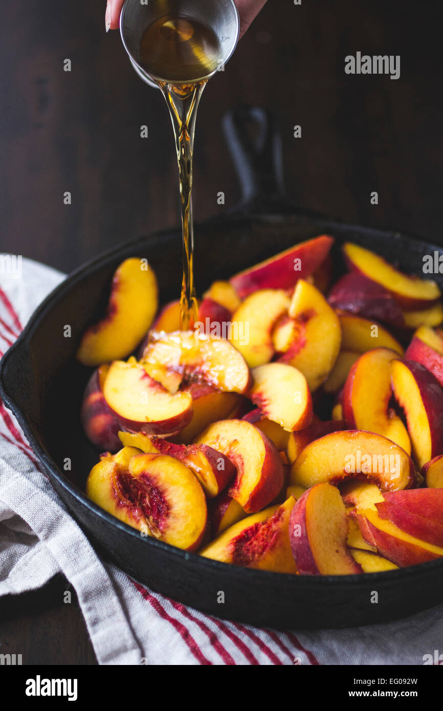 Sliced Peaches in a Cast Iron Skillet with Whiskey Stock Photo