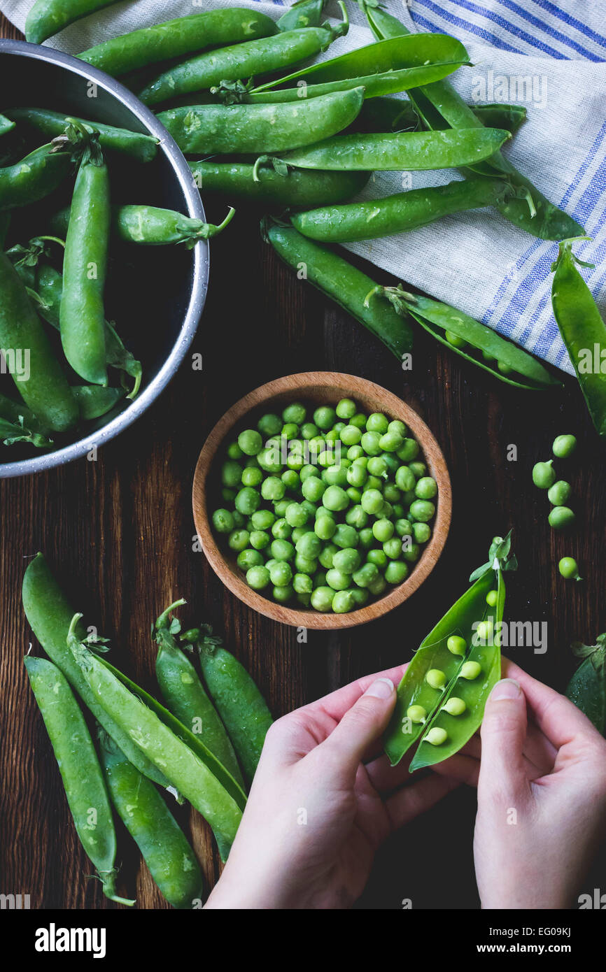 Peas being shelled from their pods Stock Photo