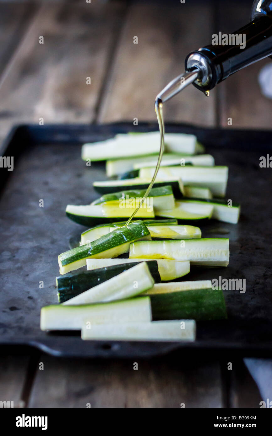 Zucchini on a baking tray with olive oil Stock Photo