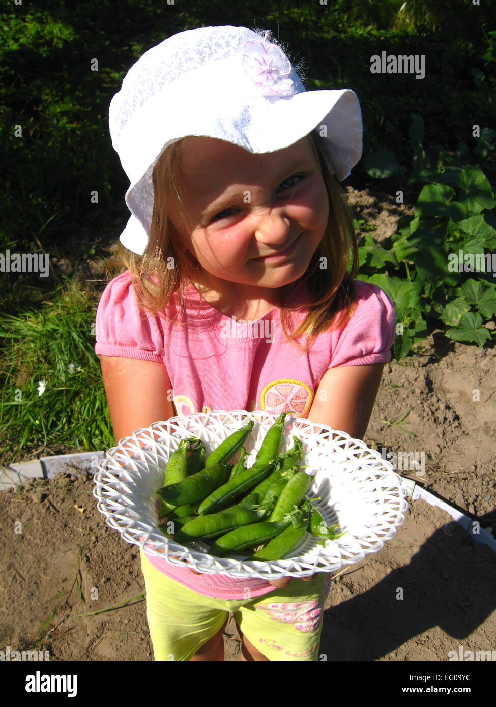image of little girl propose fresh peas Stock Photo
