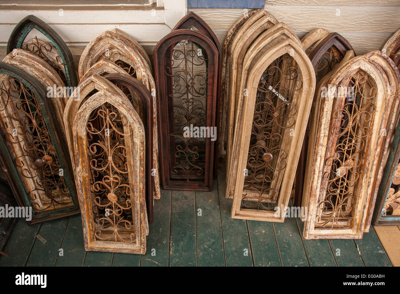 Stacks of rustic window shutters with metal scrolled decorations displayed at home decorative accessories store. Stock Photo