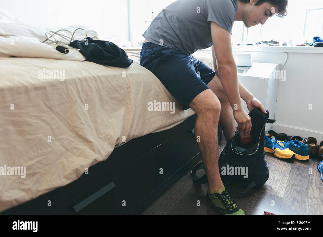Young Hispanic / Latino man in his bedroom preparing to go to gym in New York City Stock Photo