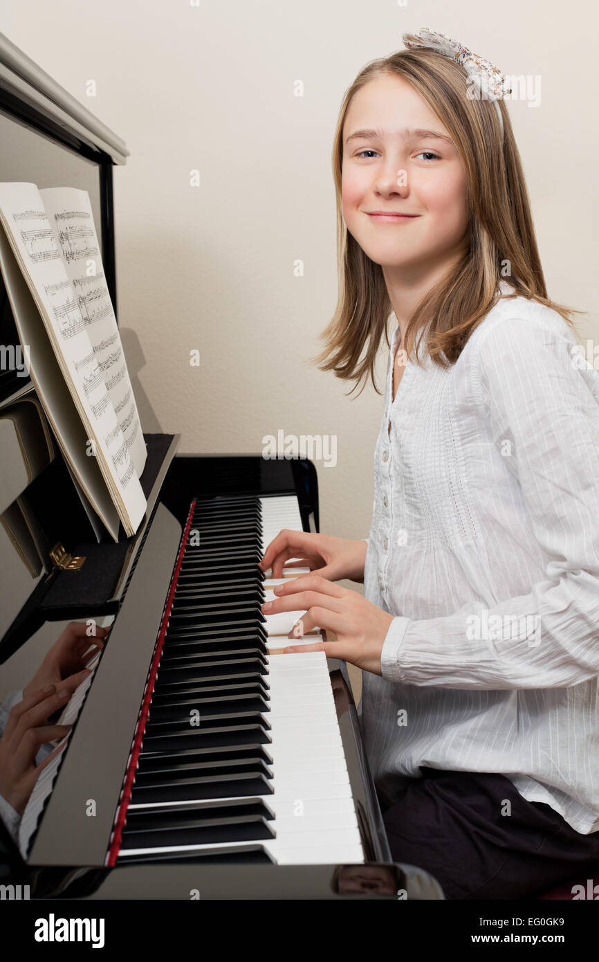 Photo of a young girl playing the piano at home Stock Photo - Alamy