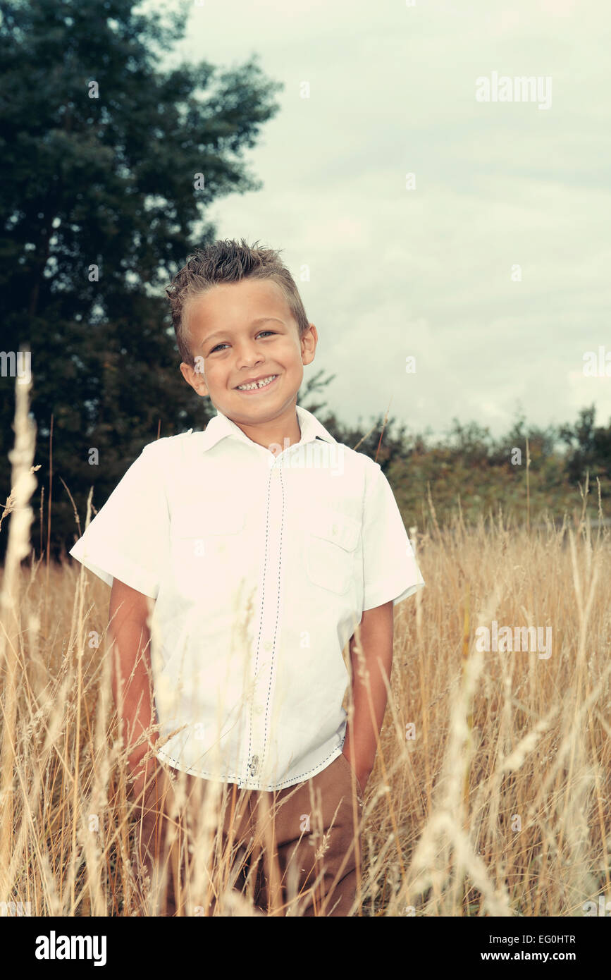 Portrait of boy amongst wild grasses Stock Photo