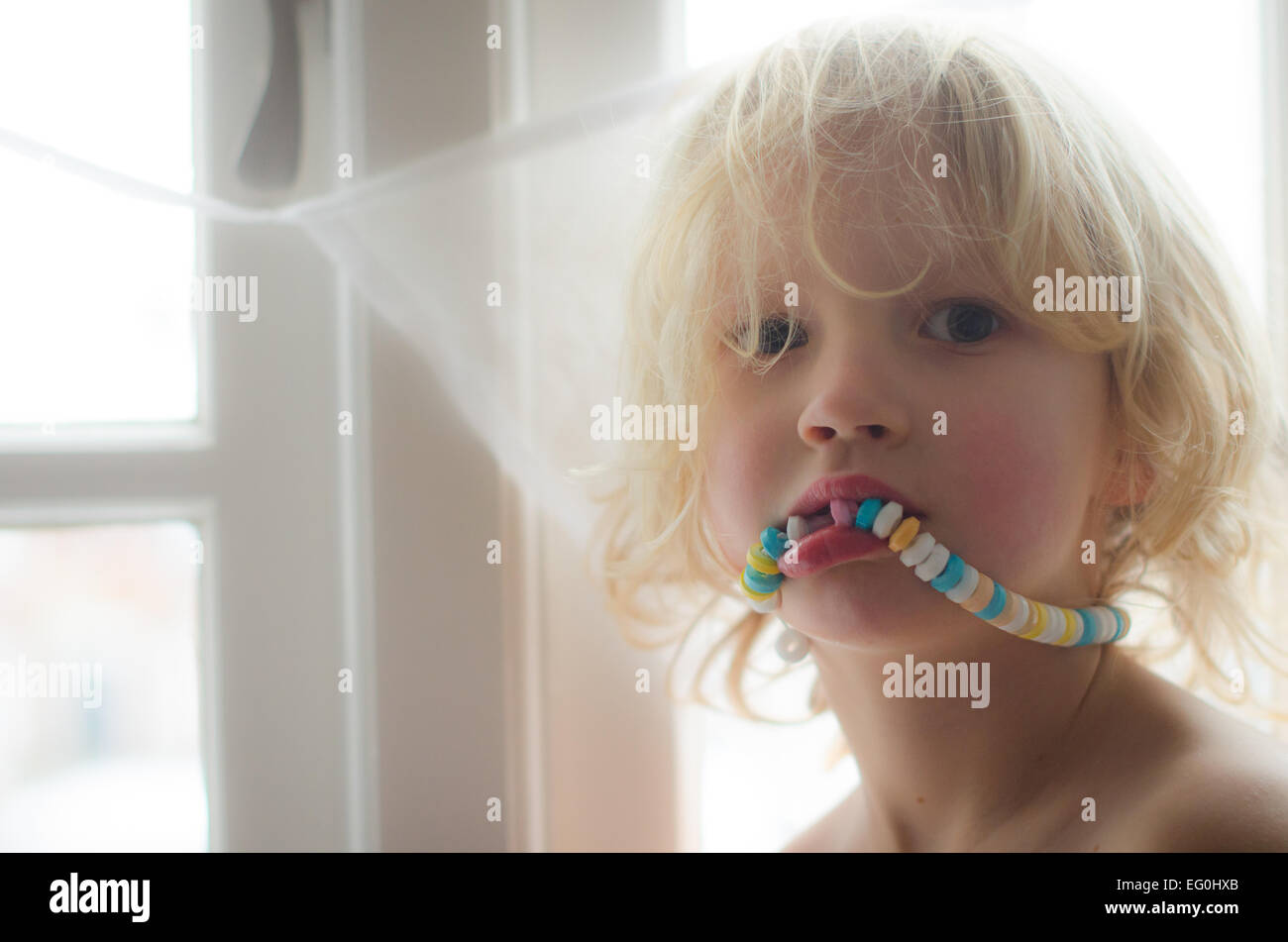 Portrait of boy eating candy necklace Stock Photo