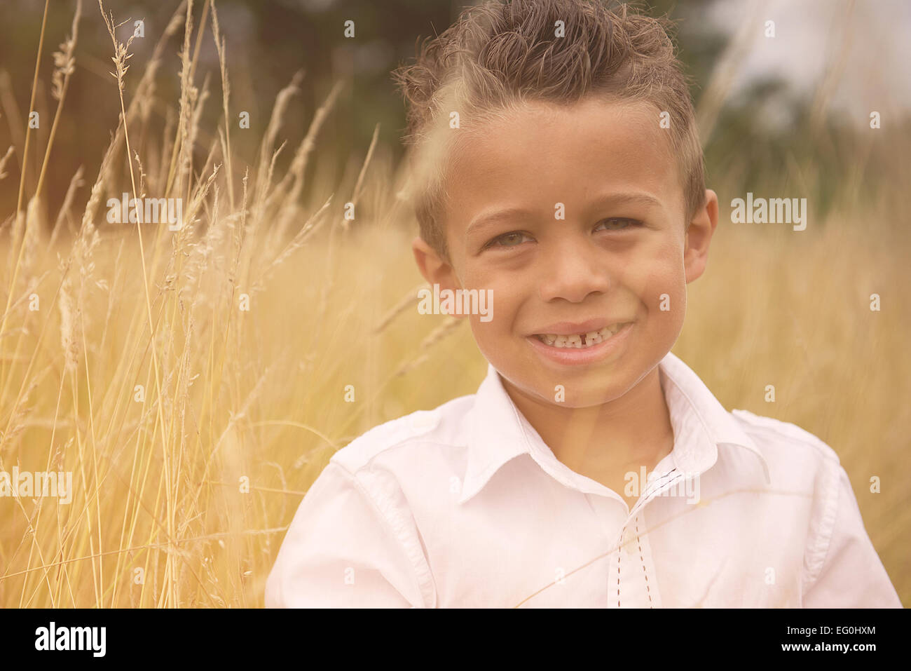 Portrait of a smiling boy standing in a field Stock Photo