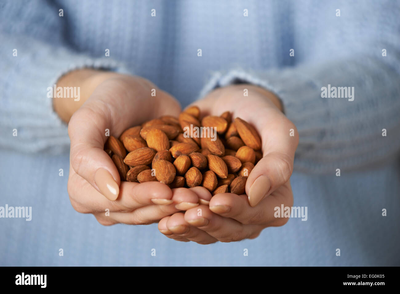 Close Up Of Woman Holding Handful Of Almonds Stock Photo