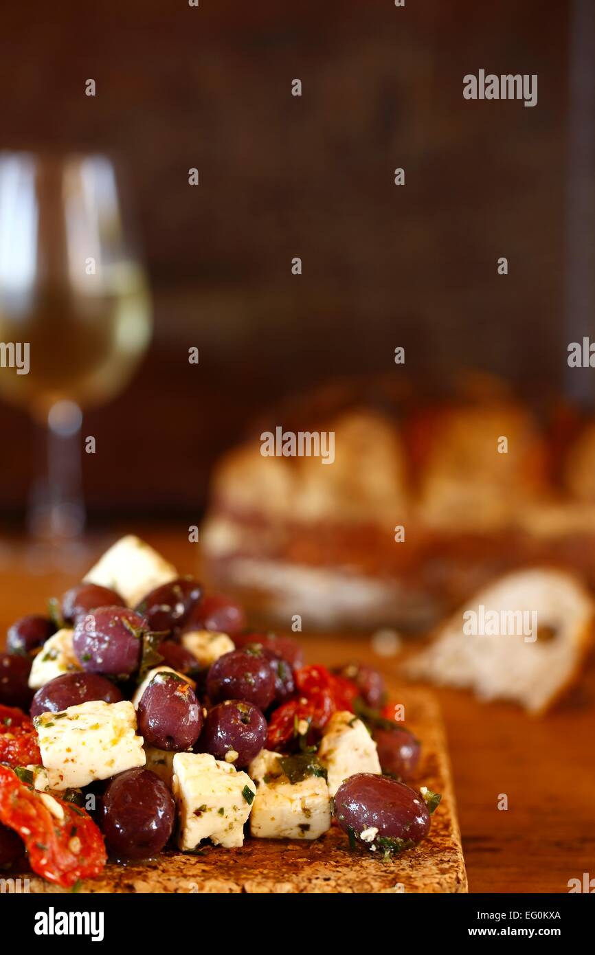 Marinated kalamata olives and feta cheese on cutting board Stock Photo