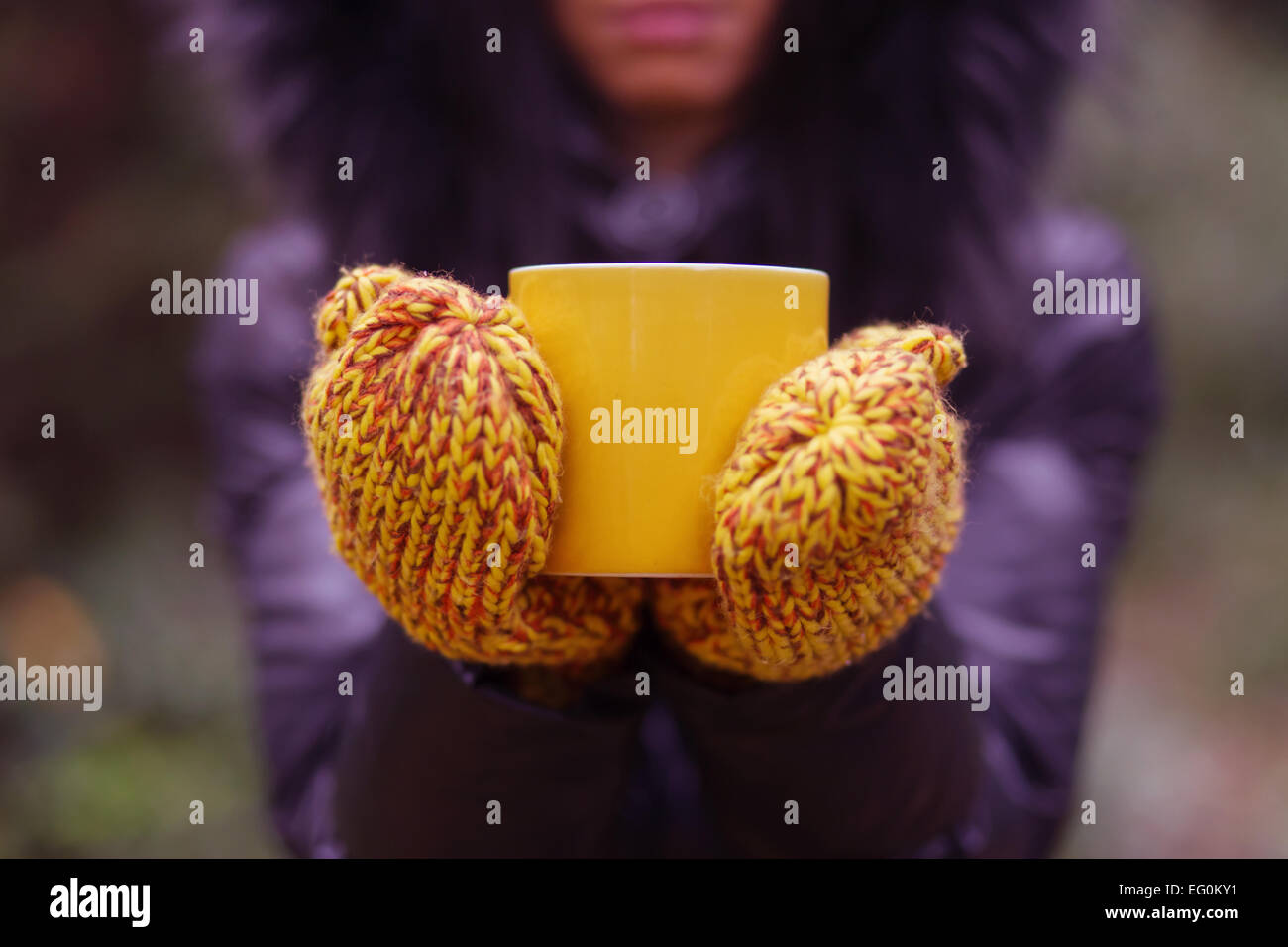 Hands with gloves holding cup of tea Stock Photo - Alamy