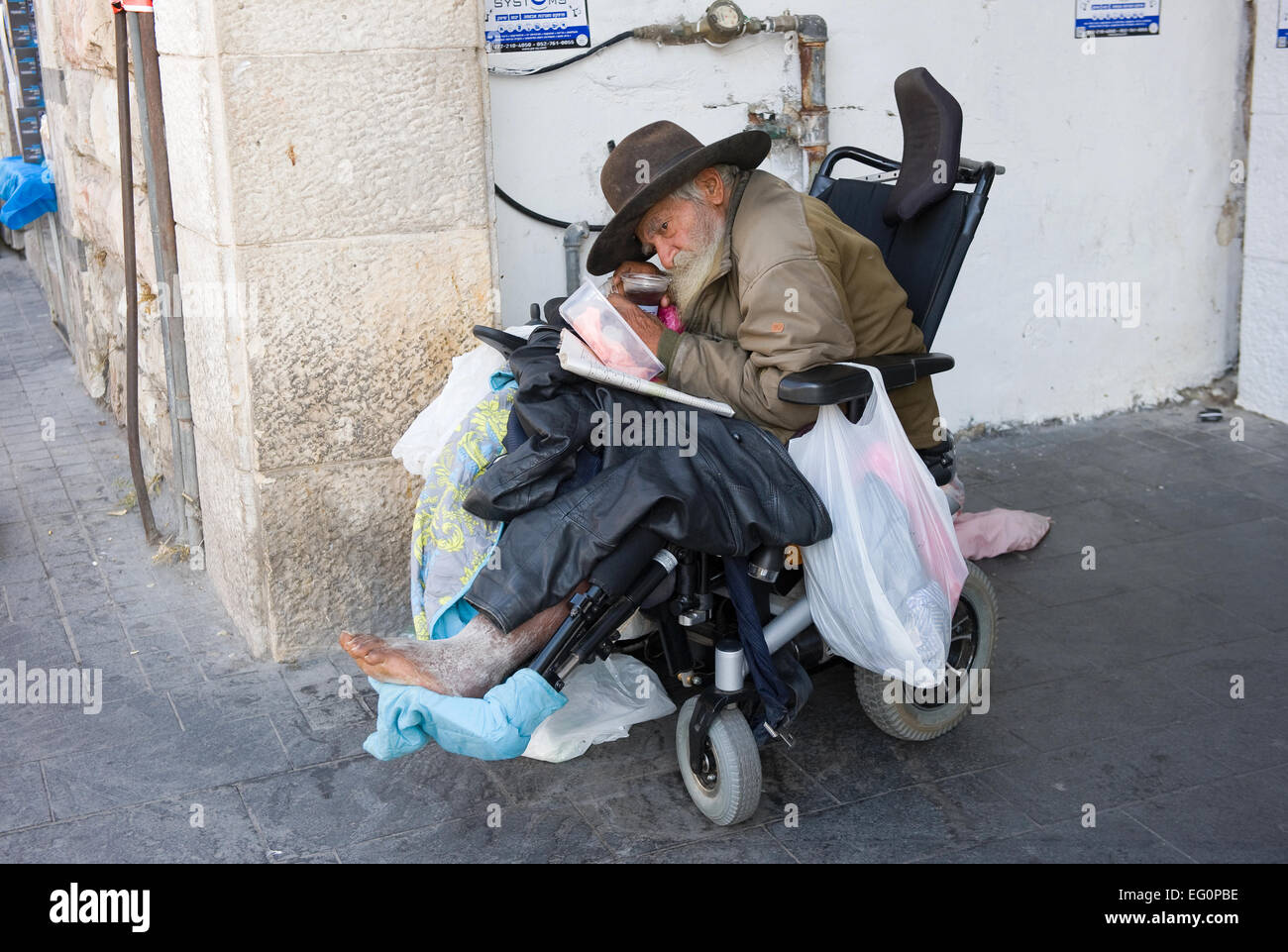 JERUSALEM, ISRAEL - 08 OCTOBER, 2014: A homeless man in a wheelchair in the streets of Jerusalem Stock Photo