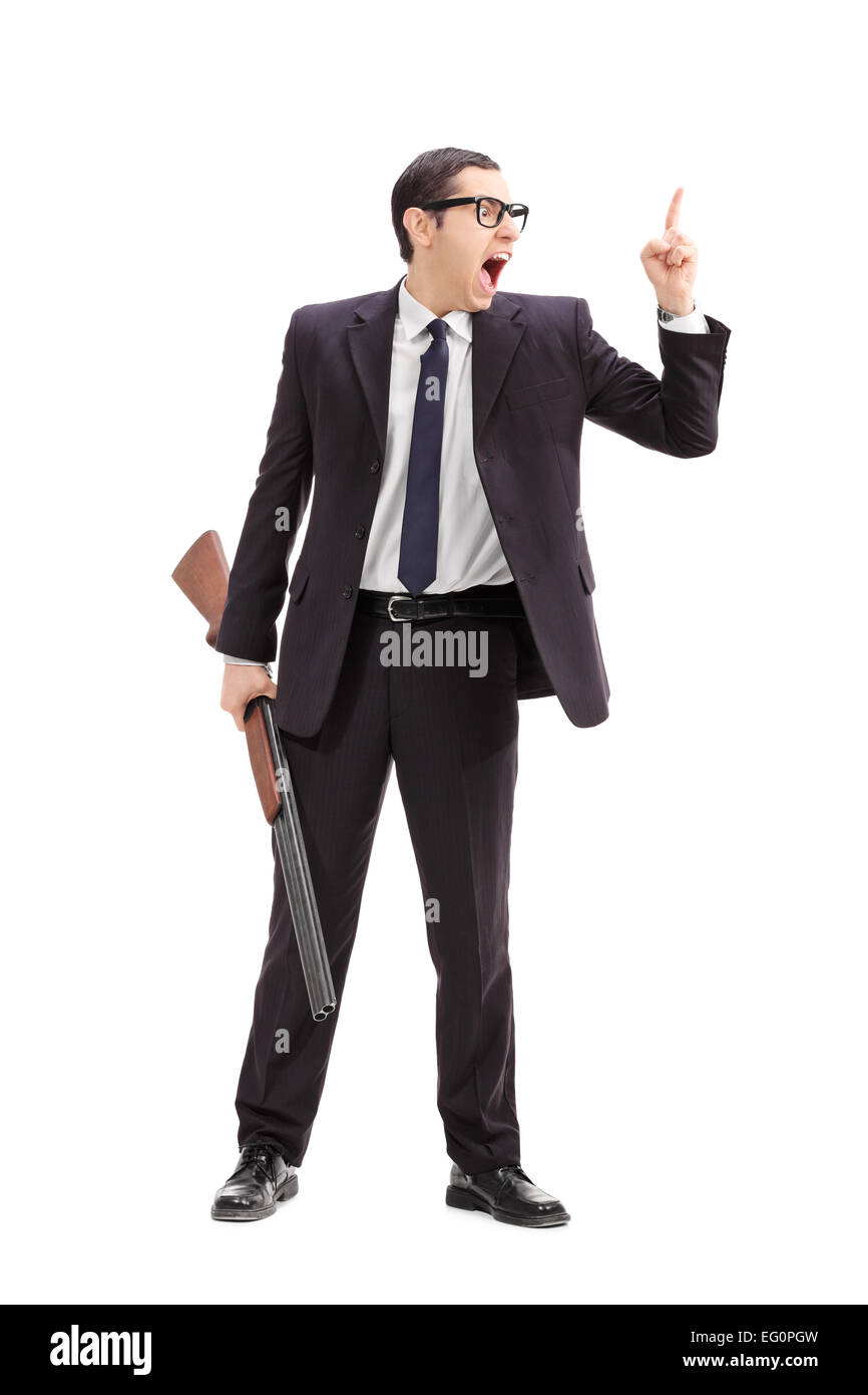 Full length portrait of an angry businessman holding a rifle and gesturing with finger isolated on white background Stock Photo