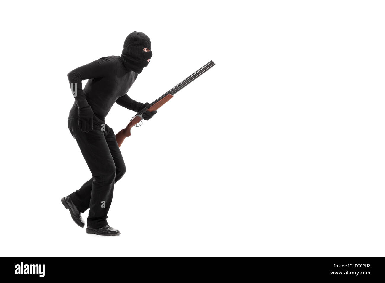 Stealthy criminal with a mask and a rifle walking isolated on white