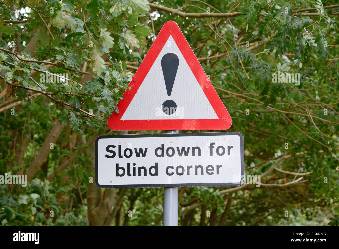 Slow down blind corner sign and symbol Stock Photo - Alamy