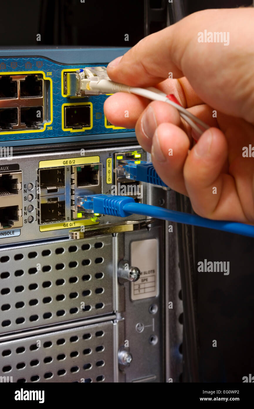 Insert /patching a fiber cable into a switch in datacenter. The visible