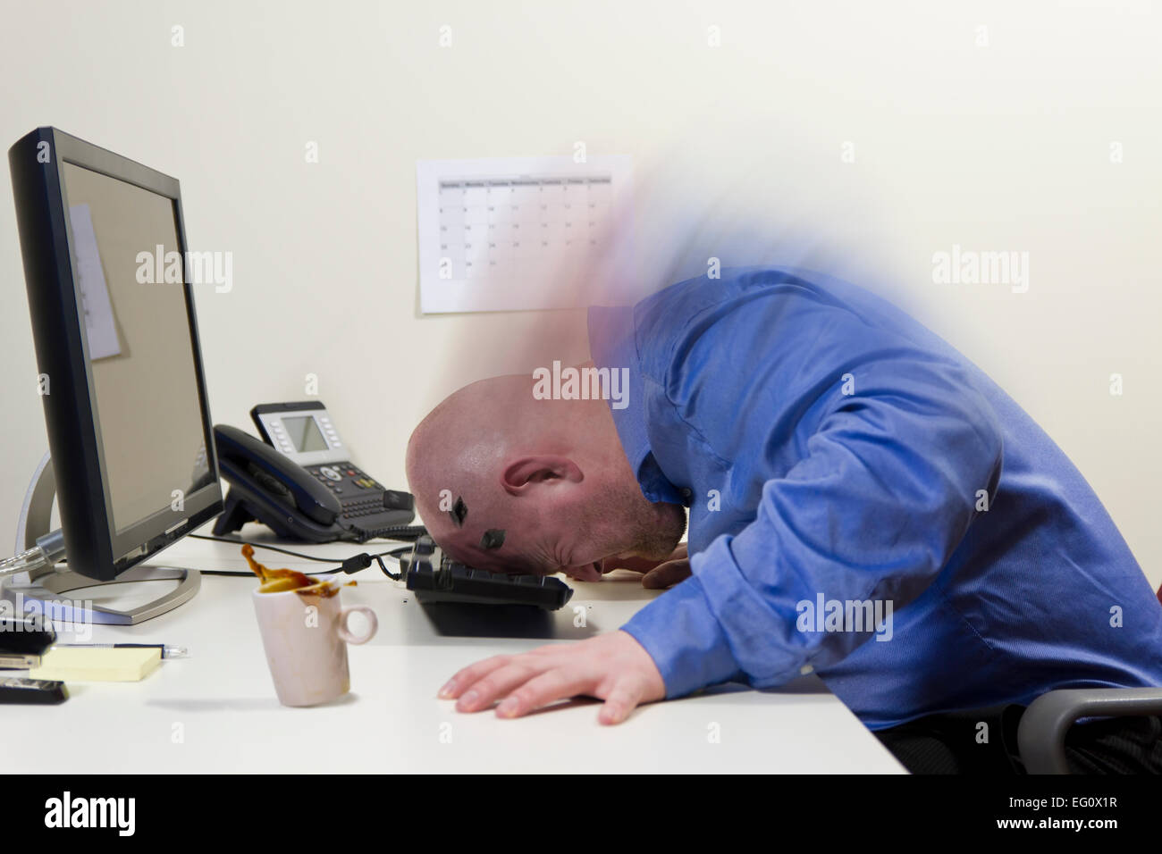 Angry office worker / businessman beats his head hard into the PC