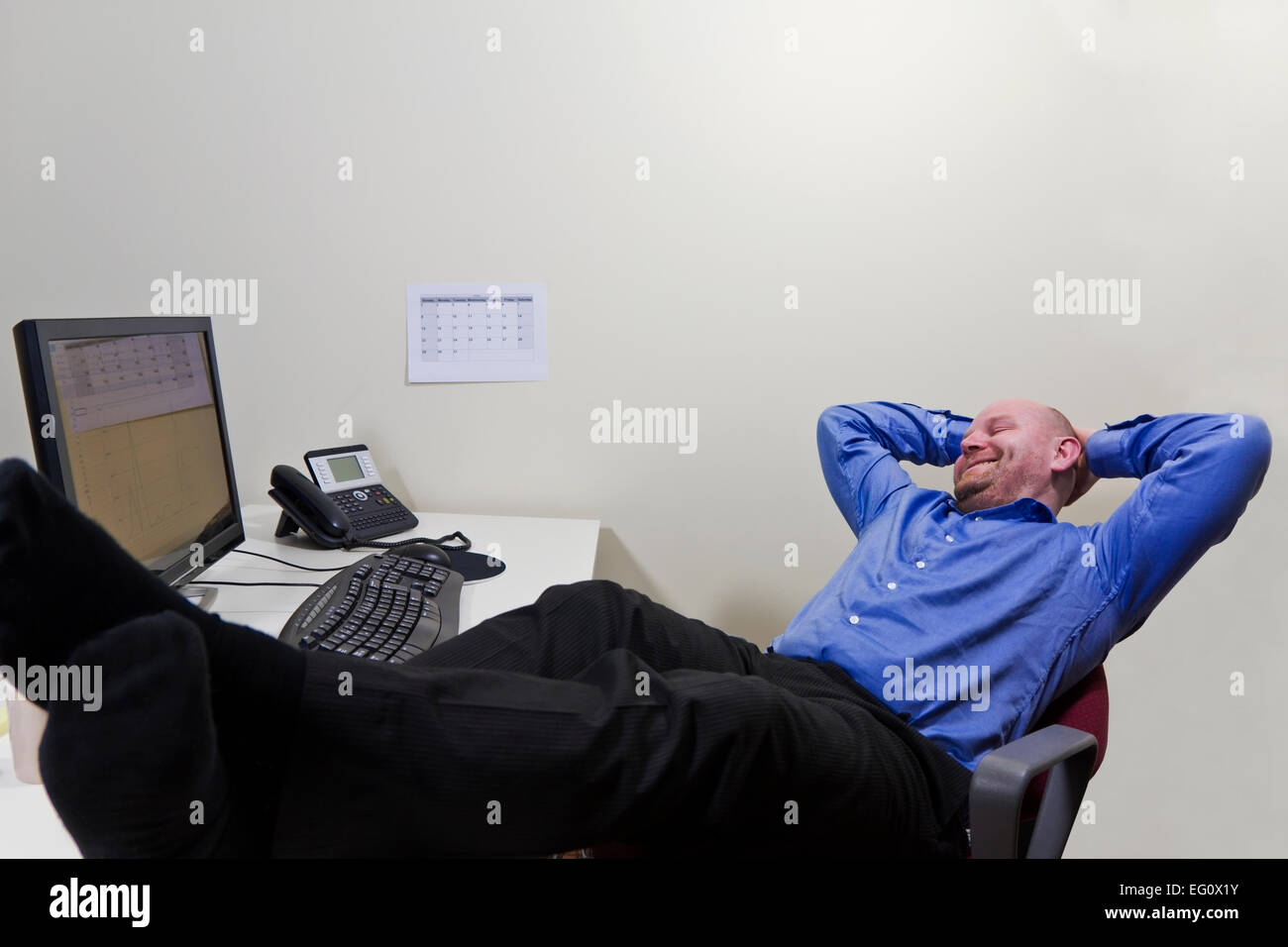 A office worker / businessman satisfied with what he has achieved. Stock Photo